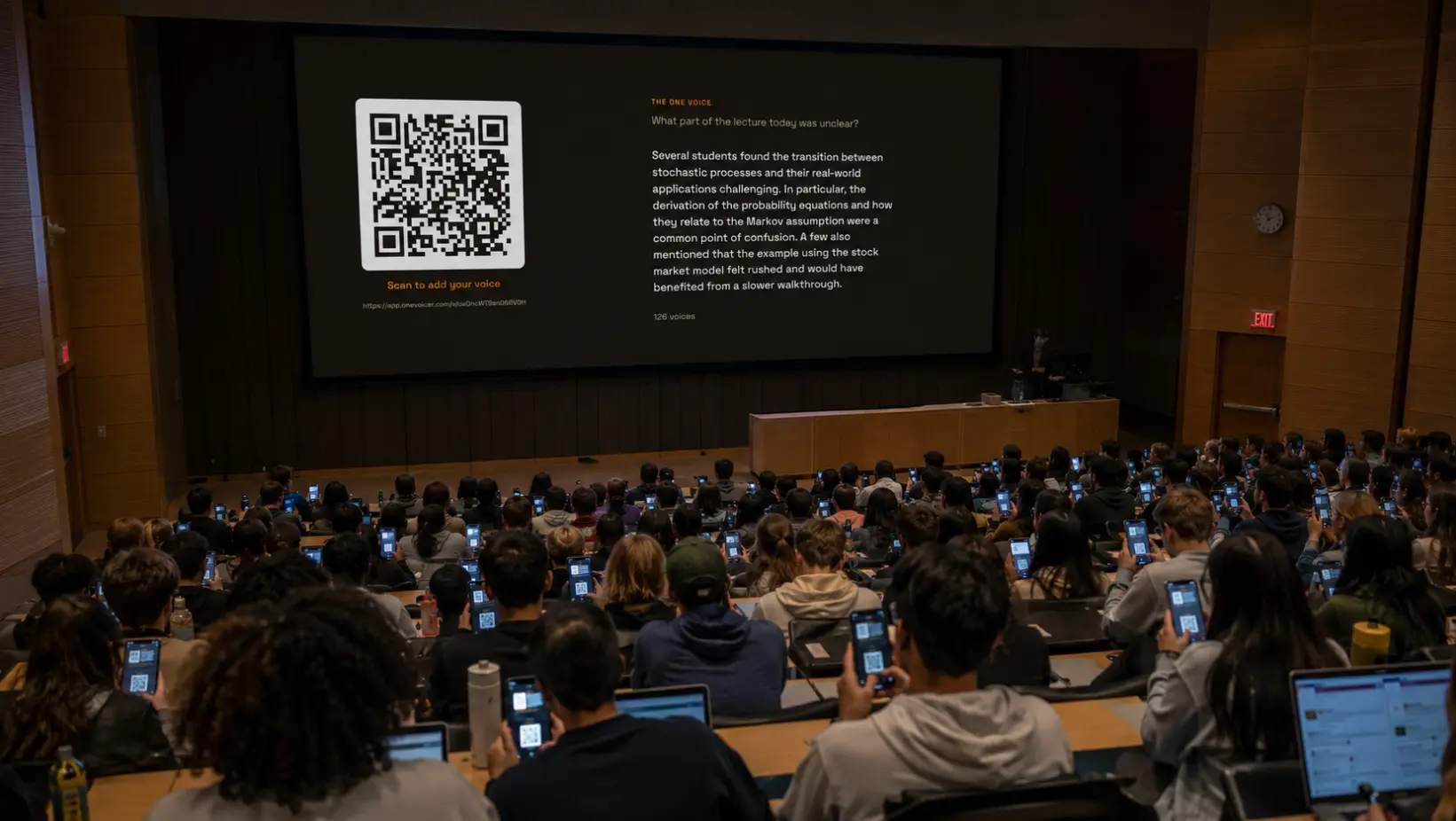 A packed university lecture hall, students holding up phones toward a large screen showing the question “What part of the lecture today was unclear?”, a QR code labelled “Scan to add your voice,” and a blended answer from 126 voices.